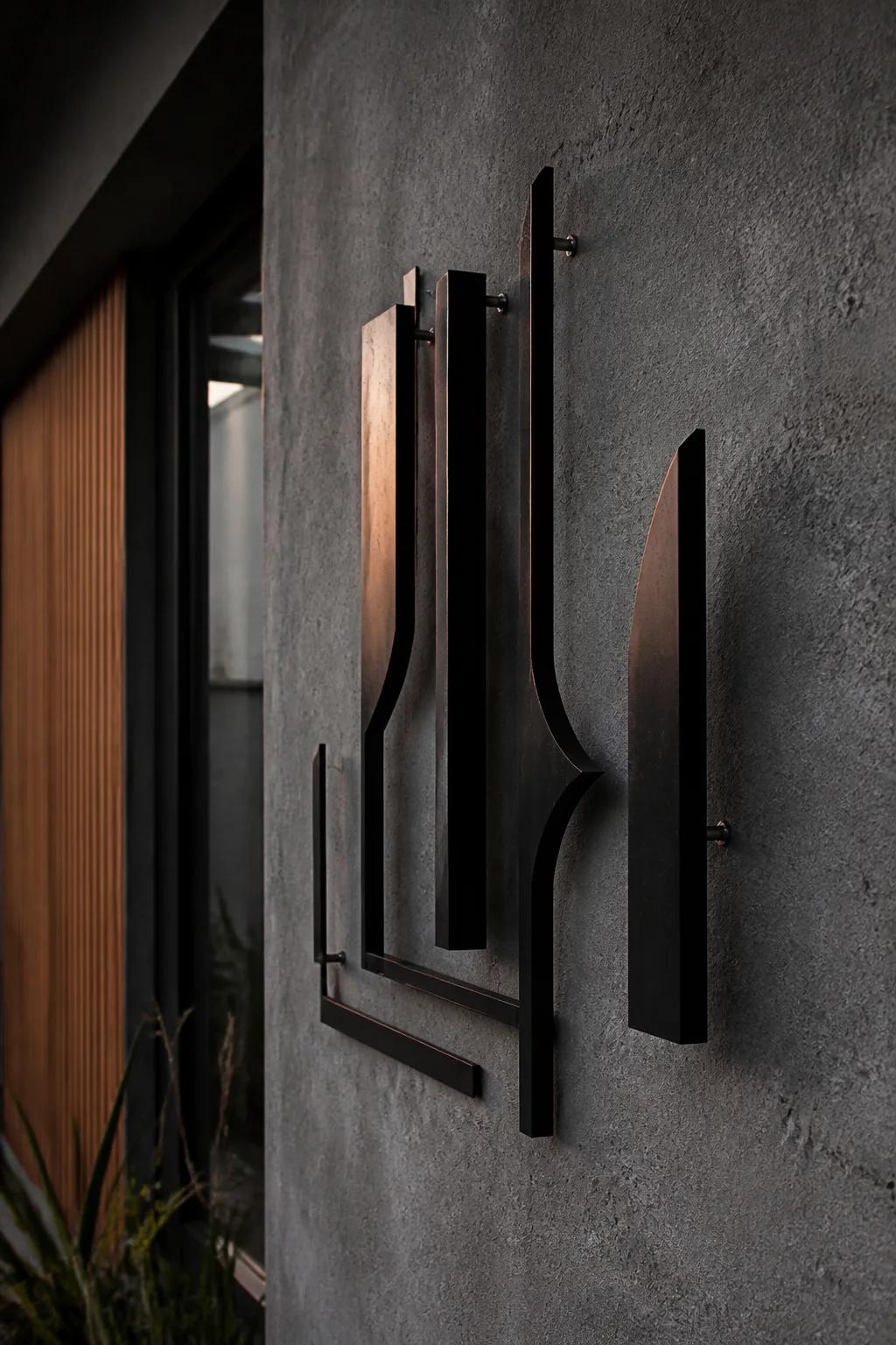 Dimensional blackened-steel signage on a dark wall